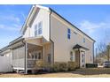 Beautiful exterior view of home with screened in porch, tan siding, dark trim, and manicured bushes at 415 Mariah Towns Way, Garner, NC 27529
