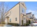 A well-maintained townhome featuring neutral siding, manicured hedges, and architectural details at 415 Mariah Towns Way, Garner, NC 27529