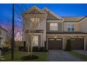 Charming two-story townhome with a stone and siding exterior, two car garage, and well maintained landscaping at 415 Mariah Towns Way, Garner, NC 27529