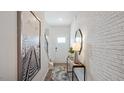 Inviting entryway featuring stylish decor, light hardwood flooring, and white brick accent wall at 434 Belgian Red Way, Wake Forest, NC 27587
