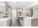 Modern kitchen featuring white cabinets, stainless steel appliances, and a large island with a sink at 528 Lemon Daisy Ln, Knightdale, NC 27545