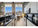 Modern kitchen with stainless appliances and granite counters, open to dining area with large windows at 614 Capital Blvd # 229, Raleigh, NC 27603