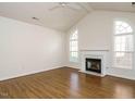 Spacious living room boasts a fireplace, vaulted ceiling, and large arched windows at 1013 Thistle Briar Pl, Cary, NC 27511