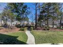 Manicured front yard with a walkway leading to the home showcasing mature trees and plantings at 116 Old Pros Way, Cary, NC 27513
