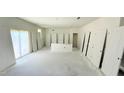 Spacious living room with white walls, sliding glass door, and a cutout for base cabinet install at 120 Gobbler Dr, Smithfield, NC 27577