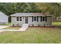 Charming single-story home with green siding, black shutters, and a well-manicured lawn at 1213 Freeman Dr, Sanford, NC 27330