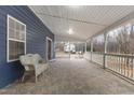Spacious covered porch featuring stone-look tile flooring and a cozy wicker chair at 12507 N Roxboro St, Rougemont, NC 27572