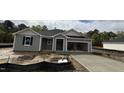 New construction home features gray siding, an attached two-car garage, and a freshly poured concrete driveway at 178 Gobbler Dr, Smithfield, NC 27577