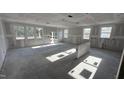 Spacious living room featuring abundant natural light with large windows and bare concrete floors at 178 Gobbler Dr, Smithfield, NC 27577