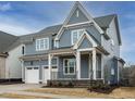 Beautiful two-story home featuring a covered porch, gray siding, and a two-car garage at 213 Big Bradley Dr, Wendell, NC 27591