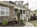 Charming front porch with stone accents, white railings, and decorative landscaping at 2570 Sweet Bay Rd, Rocky Mount, NC 27804