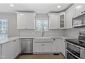 Bright kitchen features white cabinets, stainless steel appliances, and a farmhouse sink at 286 Audrey Cir, Garner, NC 27529