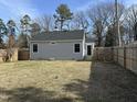 View of the backyard with a wooden privacy fence and large trees beyond the property line at 4319 Denfield St, Durham, NC 27704