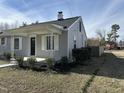 Charming home with a covered front porch and light gray siding; a freshly planted flower bed is visible at 4319 Denfield St, Durham, NC 27704