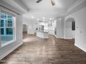 Open-concept living space with hardwood floors, connecting the living room, dining area, and kitchen at 475 Bramble Ln, Clayton, NC 27527