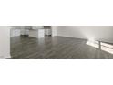 Open-concept kitchen area featuring gray wood flooring and a modern kitchen island with light countertops at 521 Old Battle Bridge Rd, Wendell, NC 27591