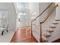 Bright foyer with hardwood floors, staircase, high ceilings, and arched doorway at 601 Walcott Way, Cary, NC 27519