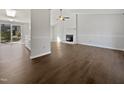 Open-concept living room with hardwood floors, fireplace, and abundant natural light at 7271 Shellburne Dr, Raleigh, NC 27612