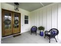 Charming covered front porch with a double-door entrance and stylish wicker chairs at 113 Nate Court Ct, Wake Forest, NC 27587