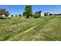 Residential home with a large lawn, trees, and installed solar panels, offering energy efficiency and environmental consciousness at 1317 Justin Oaks Ct, Willow Springs, NC 27592