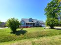 Inviting home with vibrant landscaping, lush green lawn and mature trees, providing a serene and picturesque setting at 1317 Justin Oaks Ct, Willow Springs, NC 27592