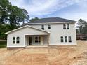 Rear view of gray two-story home with a covered porch and ample windows, surrounded by green trees at 1663 Keith Hills Rd, Lillington, NC 27546