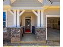 Inviting covered porch with stone accents, white pillars and an open garage at 1905 Old Bramble Ln # 4, Fuquay Varina, NC 27526