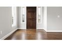 Inviting entryway with dark wood door, sidelights, and gleaming hardwood floors at 200 Single Tree Cir, Haw River, NC 27258