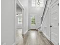 Bright foyer boasts hardwood floors, a staircase with black metal spindles, and natural light streaming through the front door at 212 Lynch Ave, Lillington, NC 27546