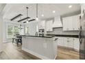 Modern kitchen featuring white cabinets, black countertops, stainless steel appliances, and a breakfast bar at 212 Lynch Ave, Lillington, NC 27546