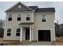 This two-story home boasts vinyl siding, an attached garage, and a classic architectural design at 260 Johnson Ridge Way, Four Oaks, NC 27524