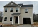 Charming two-story home with light siding, a dark roof, and an attached garage, offering classic curb appeal at 260 Johnson Ridge Way, Four Oaks, NC 27524