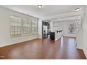 Open-concept living room with wood floors and large windows offering plenty of natural light at 2901 Benevolence Dr, Raleigh, NC 27610