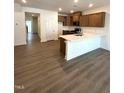 Open-concept kitchen boasts hardwood floors, modern appliances and island with quartz countertop at 328 Church St # 43, Wendell, NC 27591