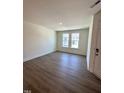 A bright living room showcasing hardwood floors and natural light from two windows at 328 Church St # 43, Wendell, NC 27591