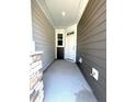 View of the covered front porch with stone pillar and white front door at 332 Church St # 45, Wendell, NC 27591