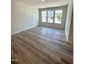 Bright living room featuring hardwood floors and three large windows at 332 Church St # 45, Wendell, NC 27591
