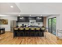 Spacious kitchen featuring black cabinets, stainless steel appliances, large island and hardwood floors at 3506 Bellevue Rd, Raleigh, NC 27609