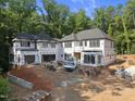 New home exterior displays brick accents, a multi-car garage, and construction materials on property at 3601 Alamance Dr, Raleigh, NC 27609
