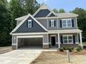 Beautiful two-story home featuring a two-car garage, craftsman details, and a well-manicured lawn in a suburban setting at 507 Olivia Crossing Ct # 20, Four Oaks, NC 27524