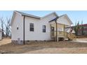 Exterior view showcasing light siding, dark roof, covered porch, and tidy lawn at 608 Gilmer St, Burlington, NC 27217
