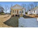 Classic single-story home with a covered porch, light siding, new concrete driveway, and well-placed windows at 614 Gilmer St, Burlington, NC 27217