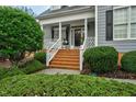 Inviting front porch with brick steps, white railings, and manicured greenery at 6489 Waters Edge Dr, Rocky Mount, NC 27803