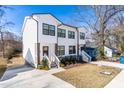 Lovely white townhouse with black framed windows, a front porch, and a driveway to the left at 1211 N Guthrie Ave, Durham, NC 27703