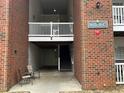 Apartment entrance with brick facade, stairs, and covered parking at 1647 Kenmore Dr, Clayton, NC 27520