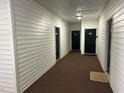 Hallway with neutral-colored carpet leading to apartment doors at 1647 Kenmore Dr, Clayton, NC 27520