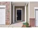 View of front door with sidelight, garage, and brick veneer at 1916 Frost Dr, Haw River, NC 27258