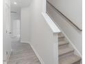 Hallway and carpeted stairs with white walls and grey laminate floors at 1916 Frost Dr, Haw River, NC 27258