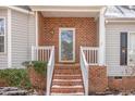 Inviting front porch with brick steps, white railings, and a brick facade adds curb appeal at 2623 Broad Oaks Pl, Raleigh, NC 27603