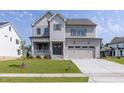Attractive home featuring a covered front porch, well-kept lawn, and attached two-car garage at 3521 Amelia Grace Dr # 67, Fuquay Varina, NC 27526